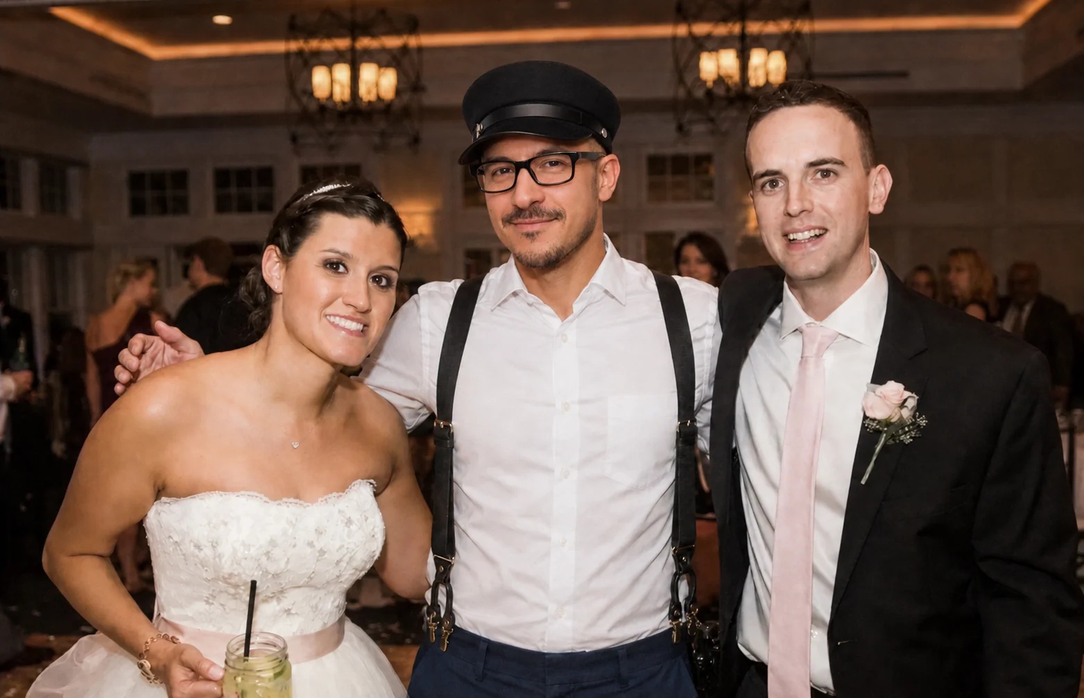 Arman between a bride and groom at their venue, all three laughing