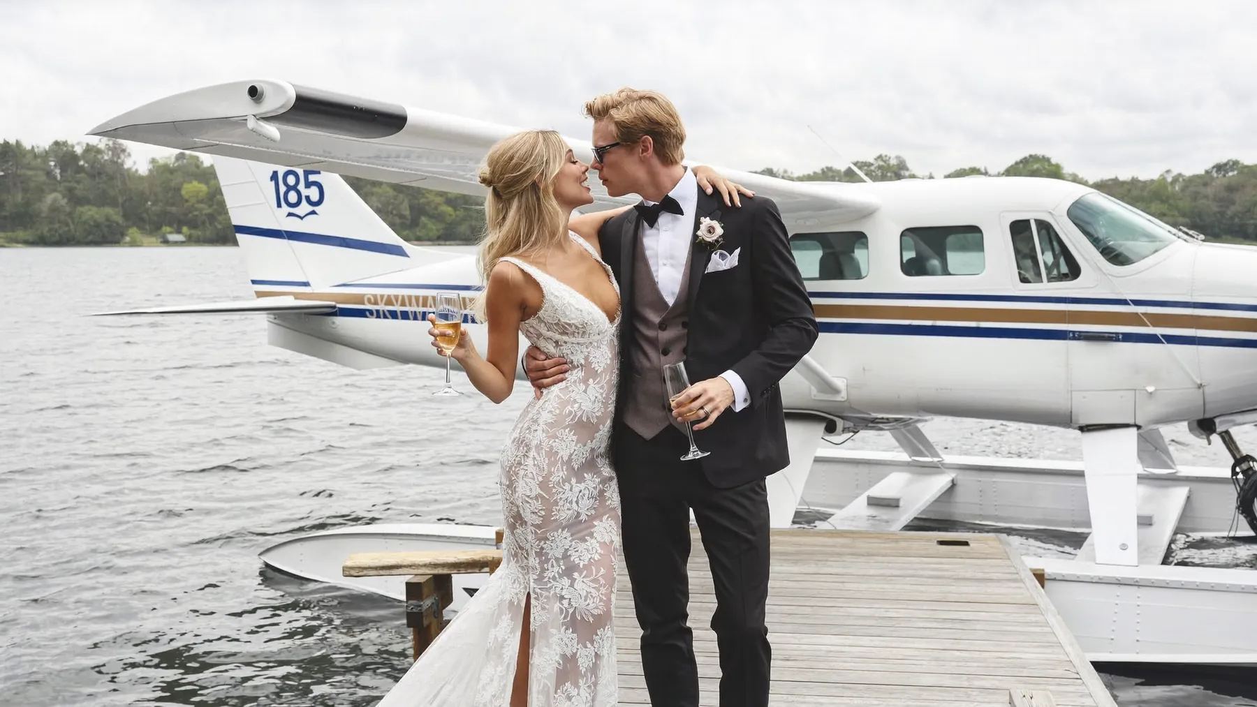 Couple on a dock in front of a float plane on a Muskoka lake