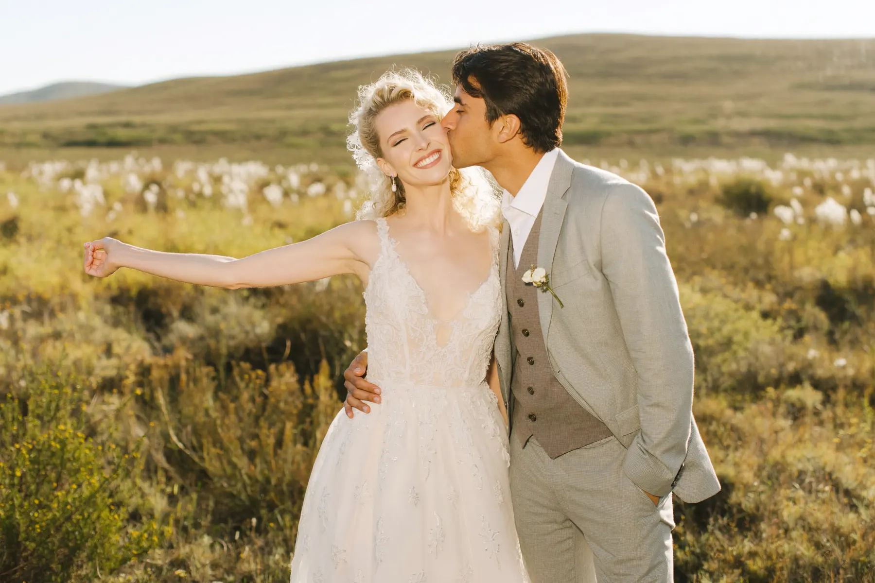 Couple laughing in a golden grass field in Prince Edward County