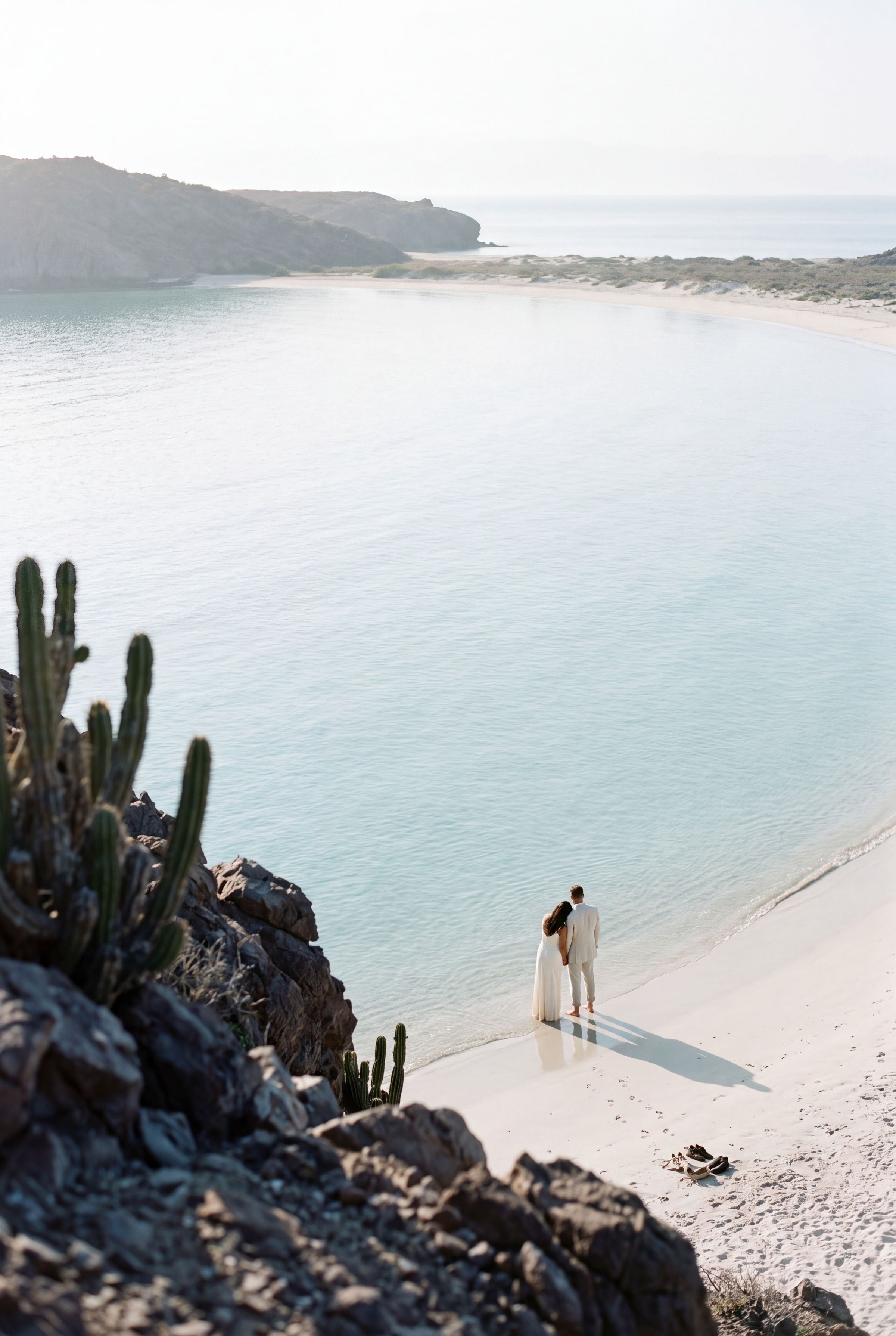 A wide bay with pale sand and cactus on the headland in Baja California Sur