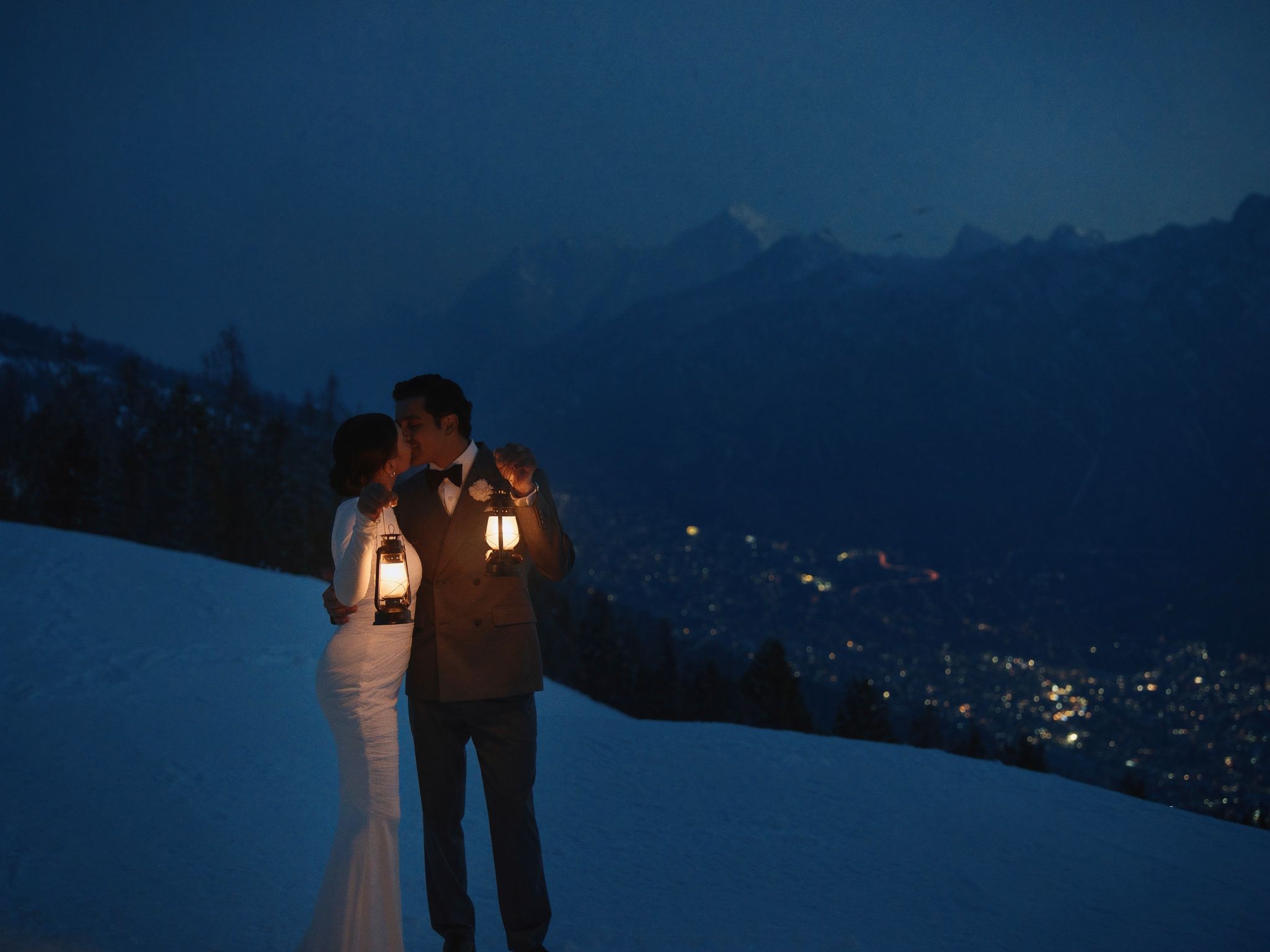 A couple holding a lantern at dusk in the mountains above Banff