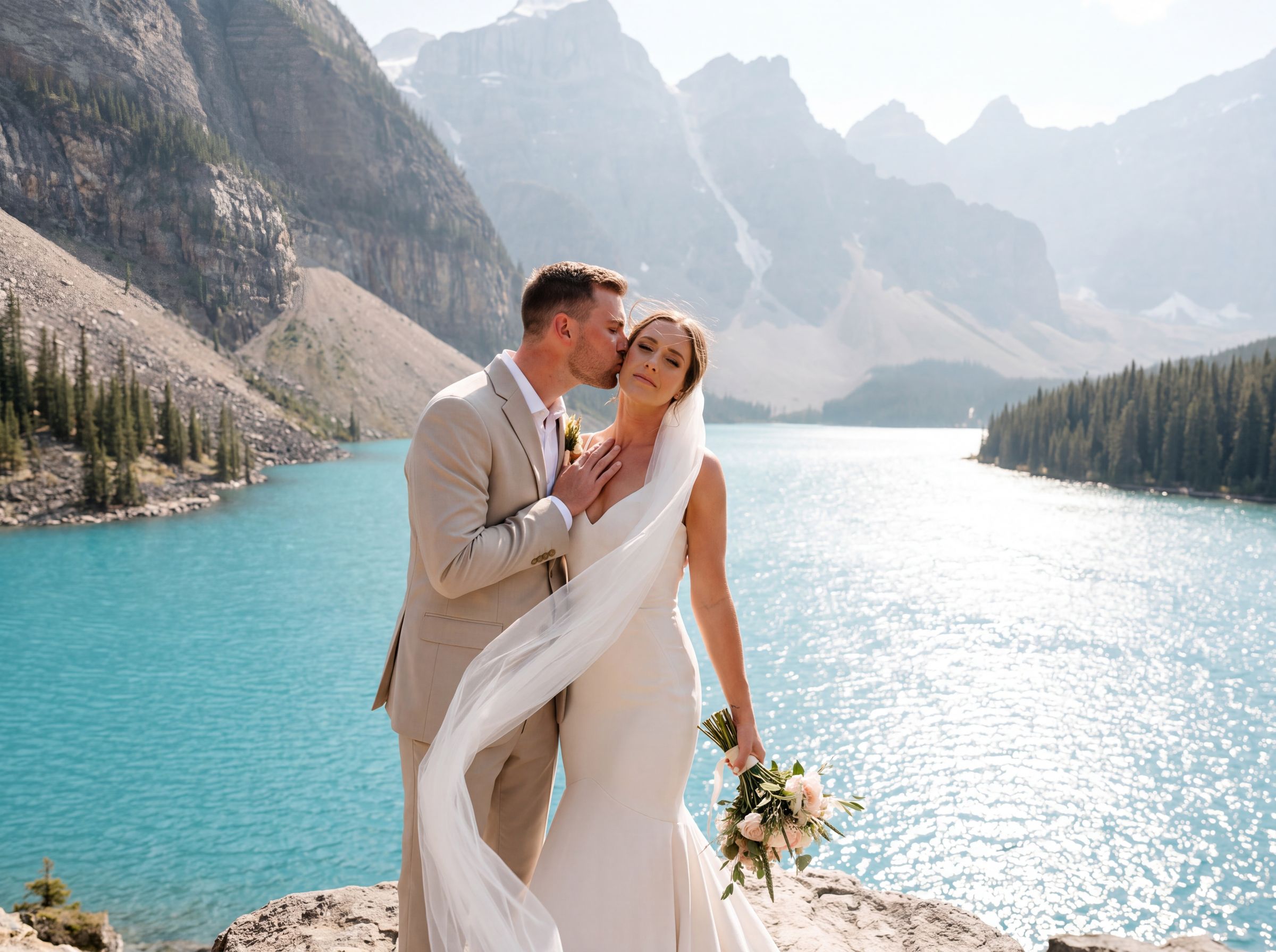 A couple kissing on the shore of Moraine Lake below the Valley of the Ten Peaks