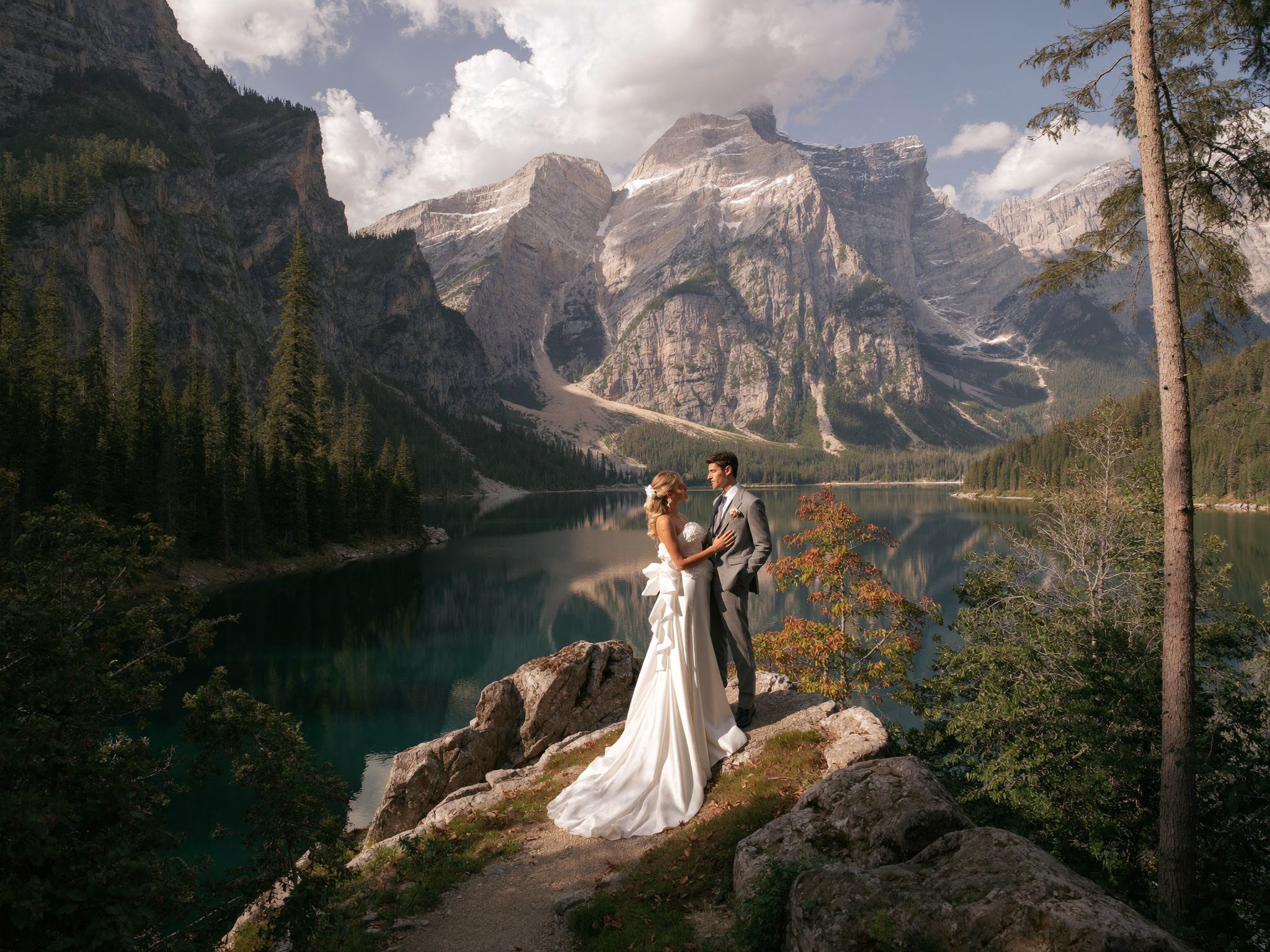 A couple on a rock ledge above a glacial lake in the Canadian Rockies, photographed by Arman Arai