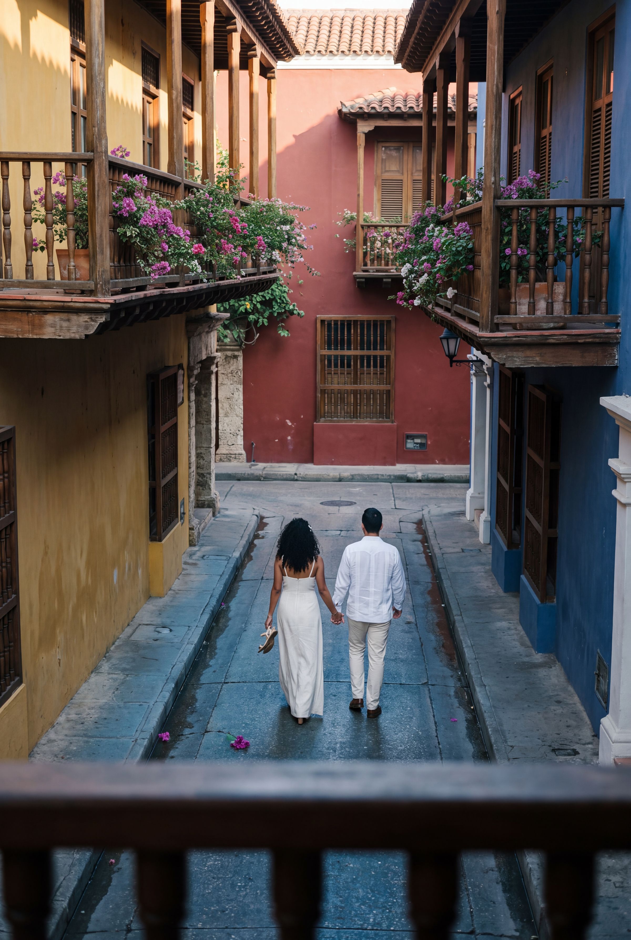 A couple walking away down an empty colonial street in Cartagena at first light