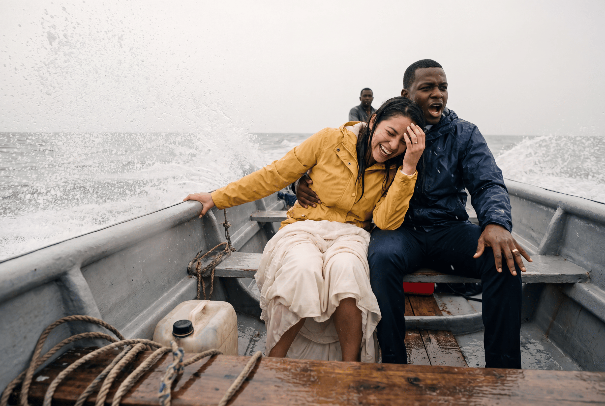 A couple sheltering together in heavy rain on a Chocó beach