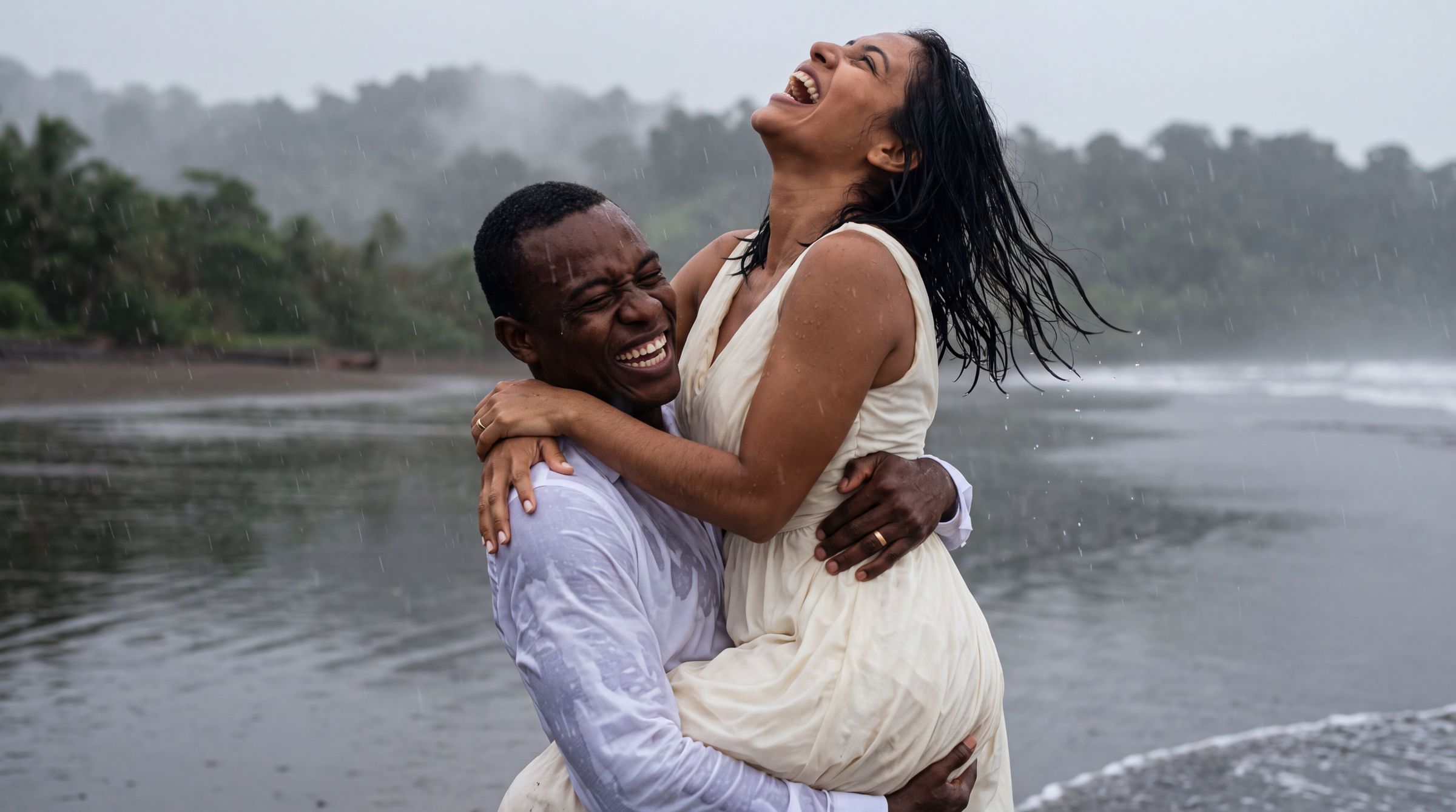 A couple embracing in shallow water on a dark sand beach in Chocó