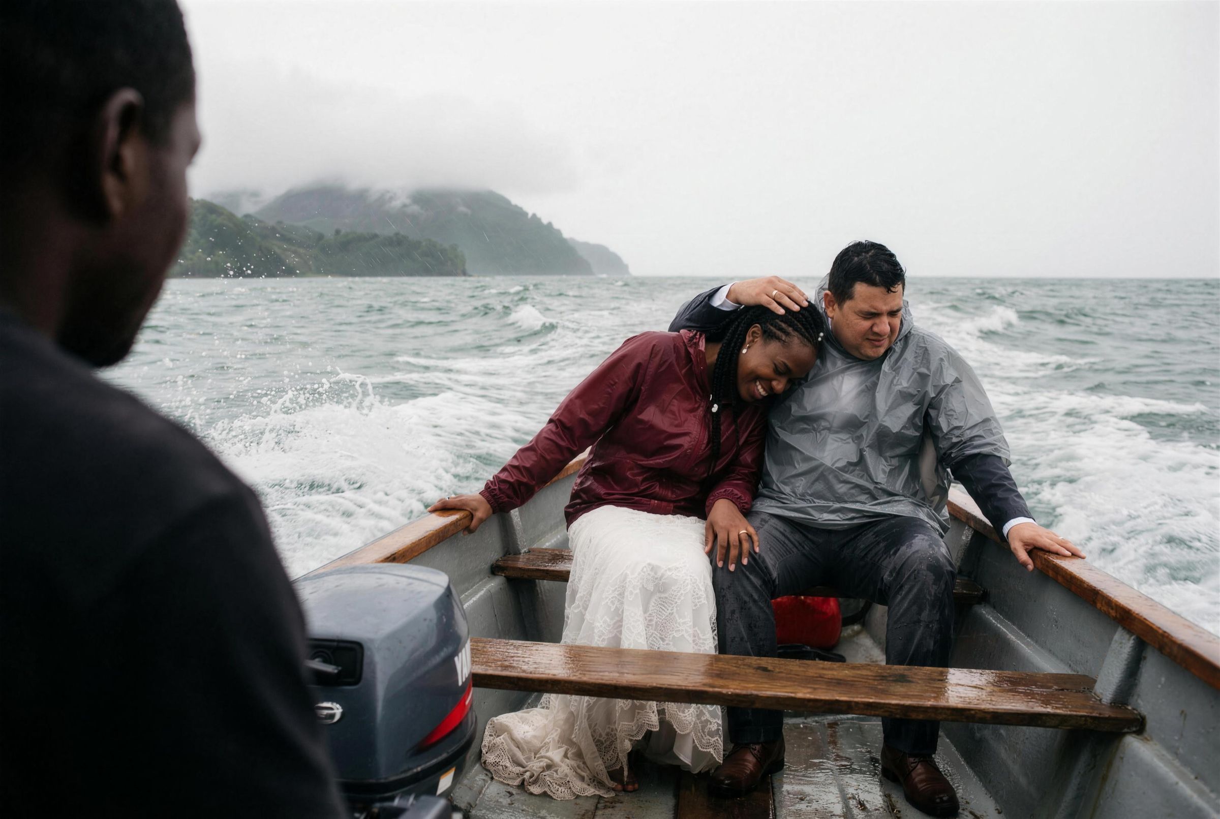 A couple in a small boat in rain gear on grey water off the Chocó coast