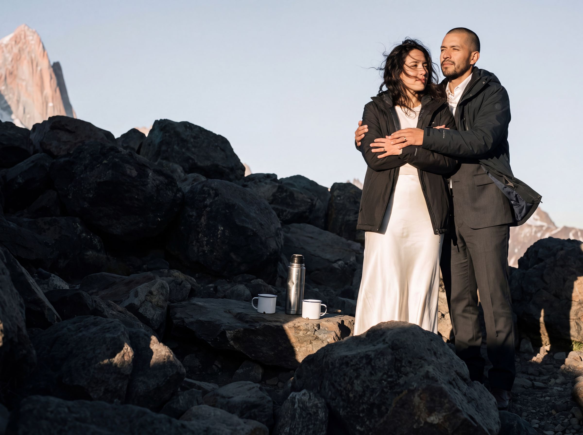 A couple sharing a jacket on the scree at first light