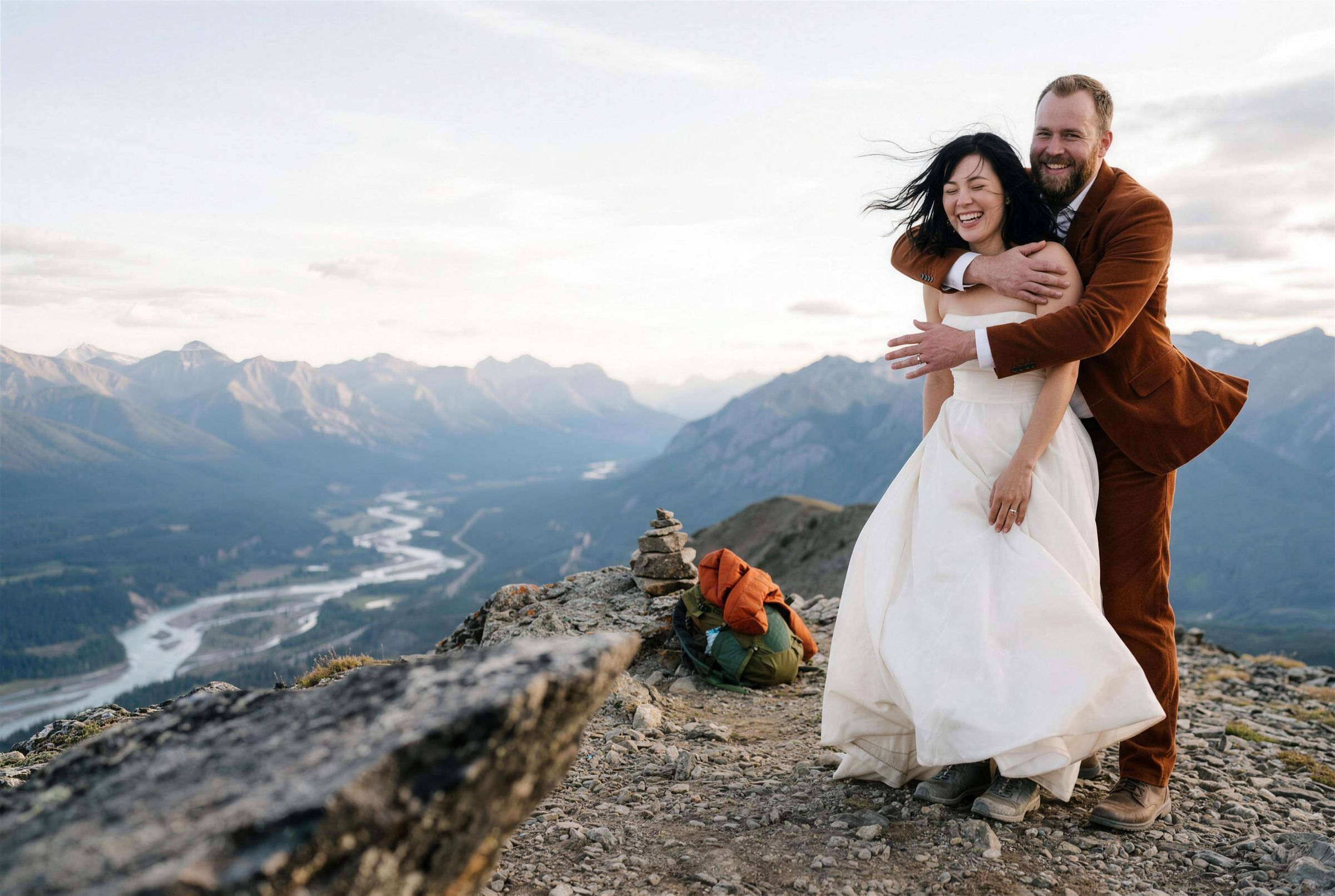 A couple on a ridge above a wide braided river valley in Jasper