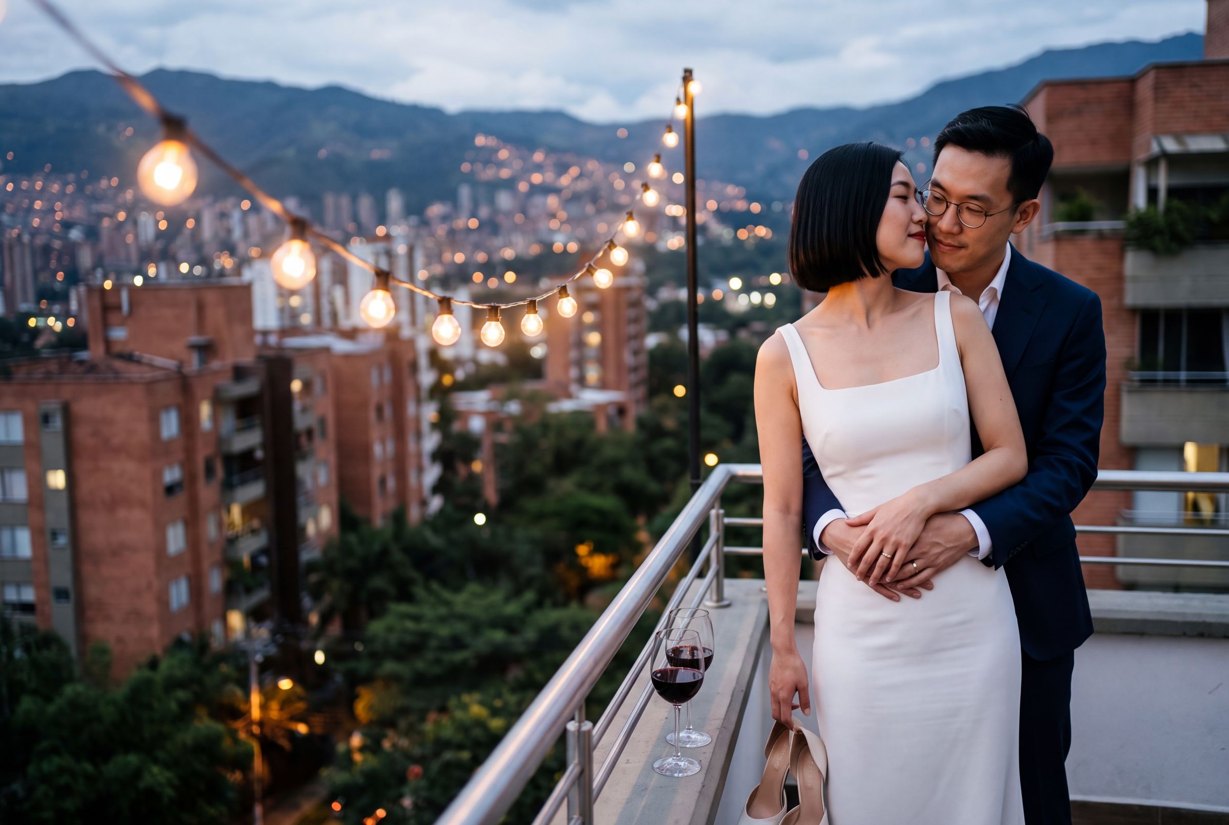 A couple on a rooftop above the lights of Medellín at dusk