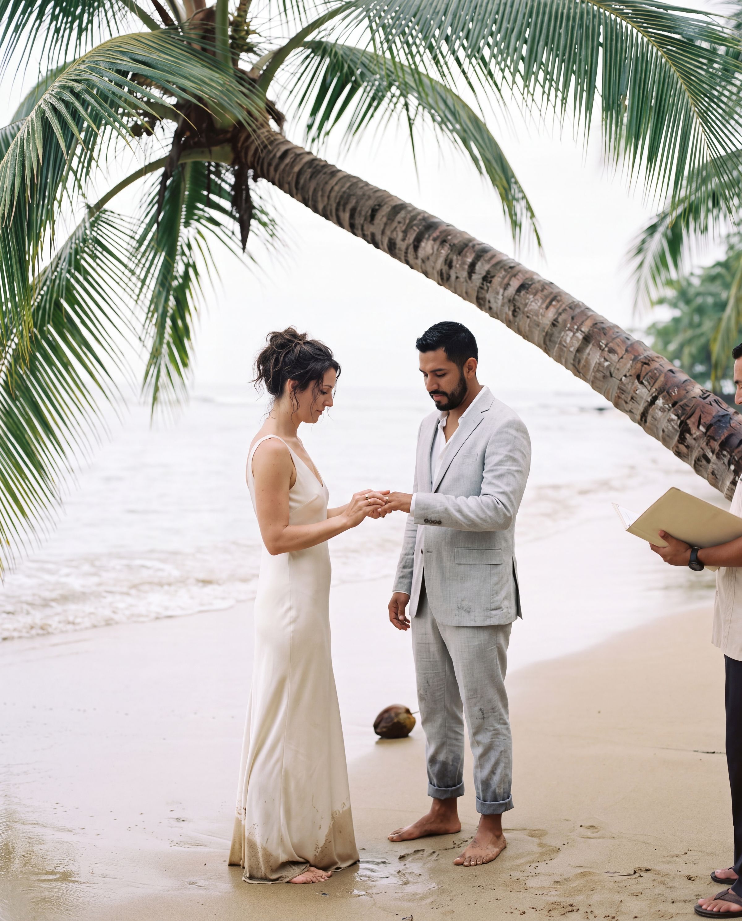 A ceremony under leaning palms on pale sand