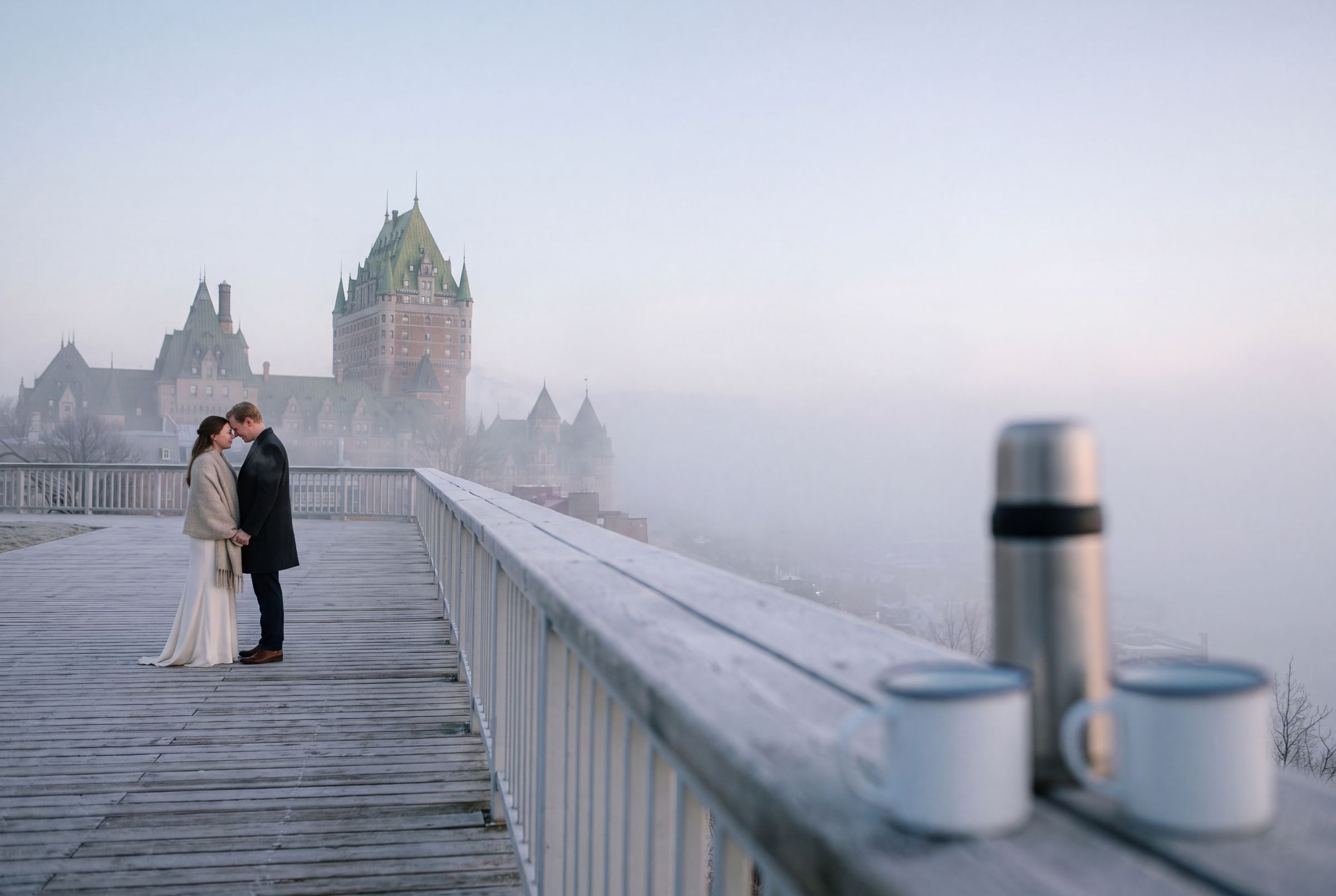 The Château Frontenac dissolving in river fog above an empty boardwalk at dawn