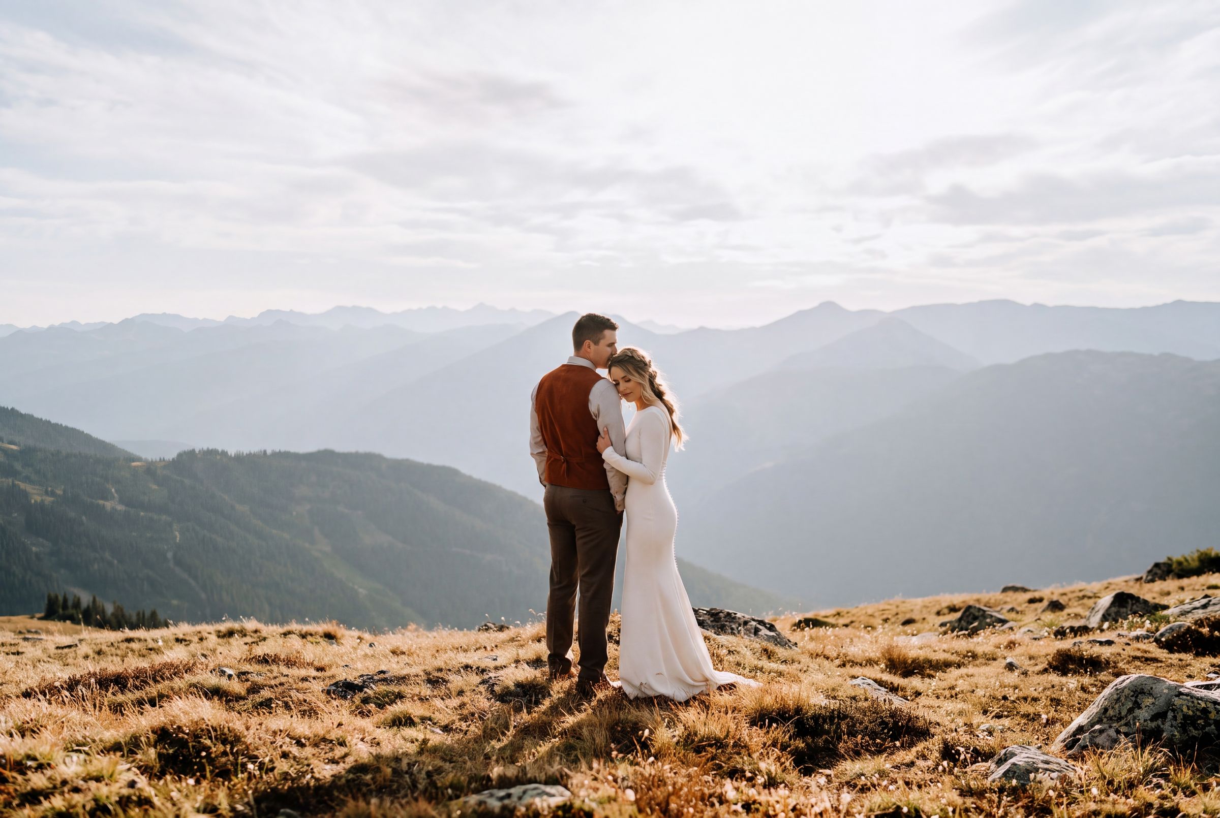 A couple standing on an open alpine meadow above the Coast Mountains near Whistler