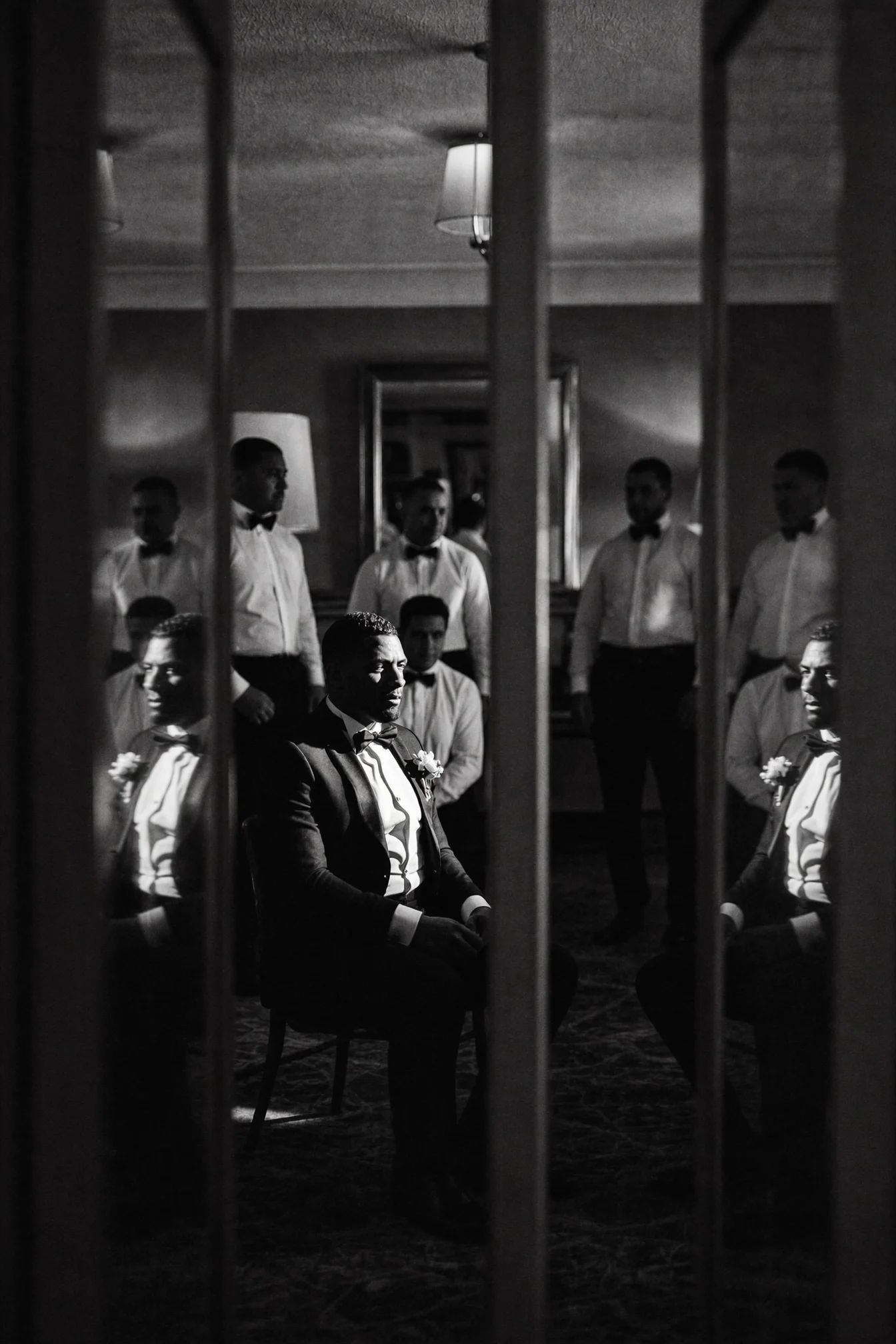 Black and white frame of the wedding party repeated in mirrored doors
