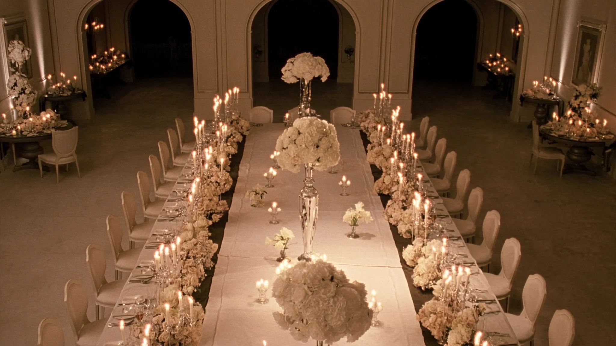 A long banquet table set and lit entirely by candles