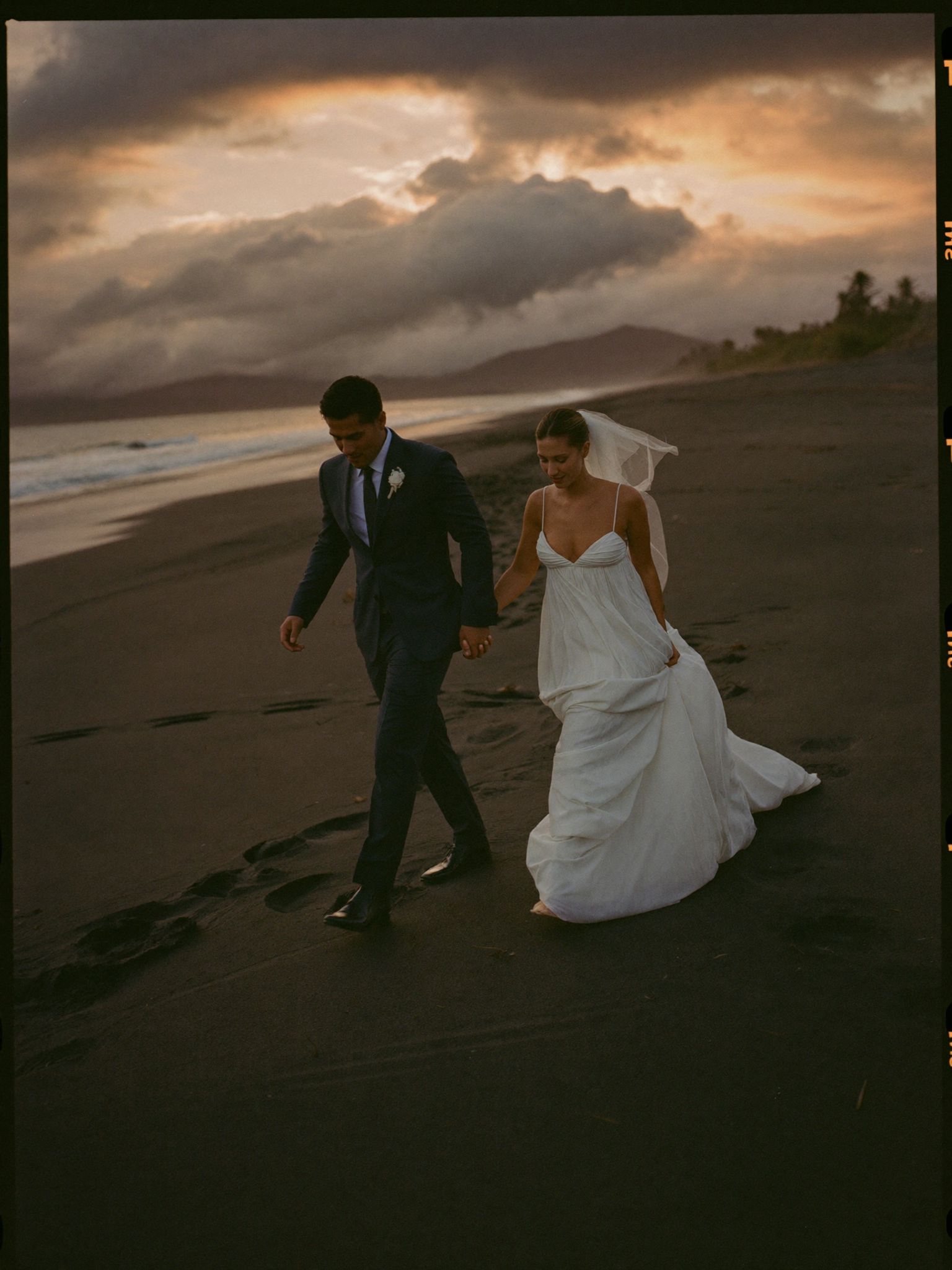 A couple walking back along the sand at sunset in Guanacaste