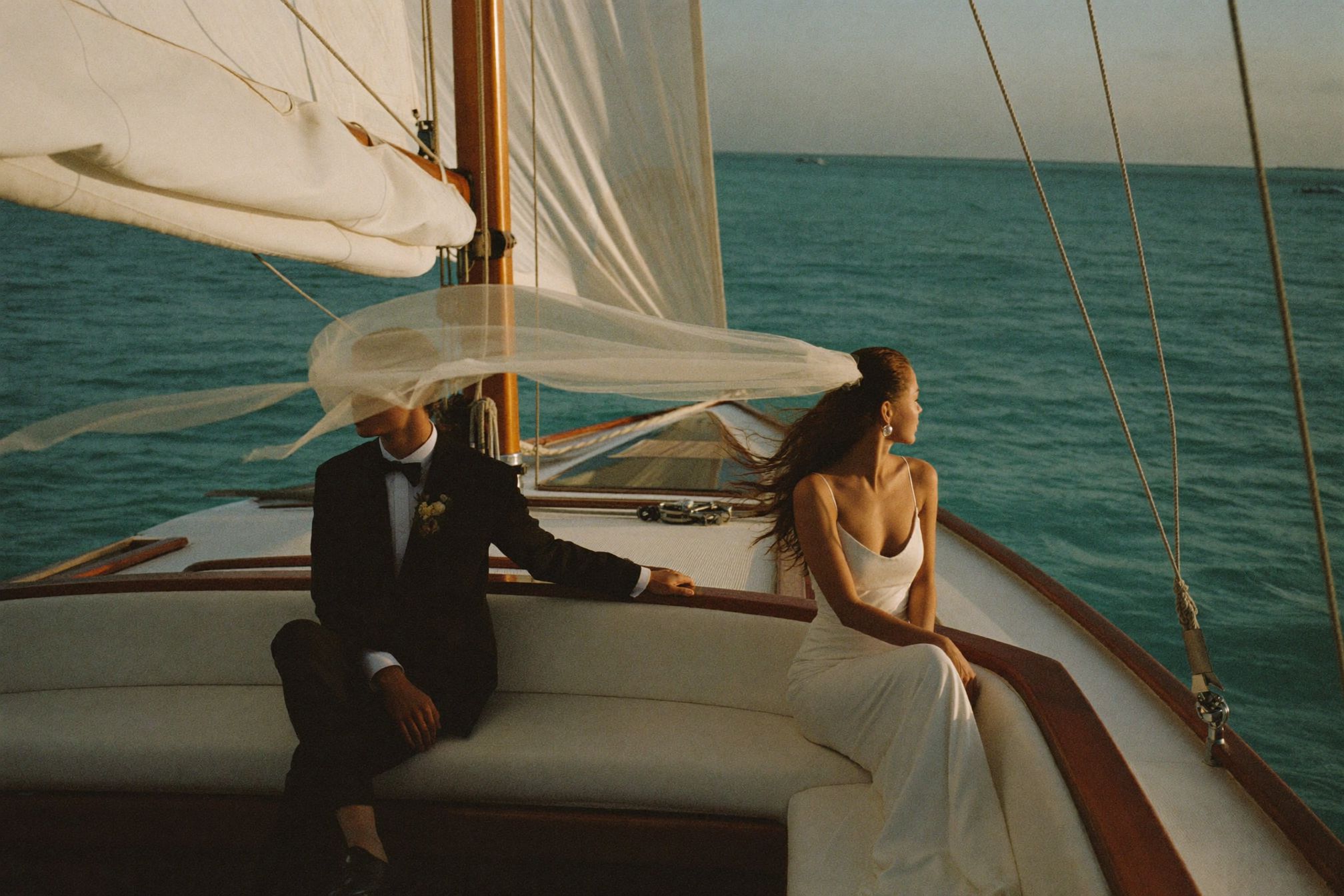 A catamaran under sail off the Caribbean coast at sunset
