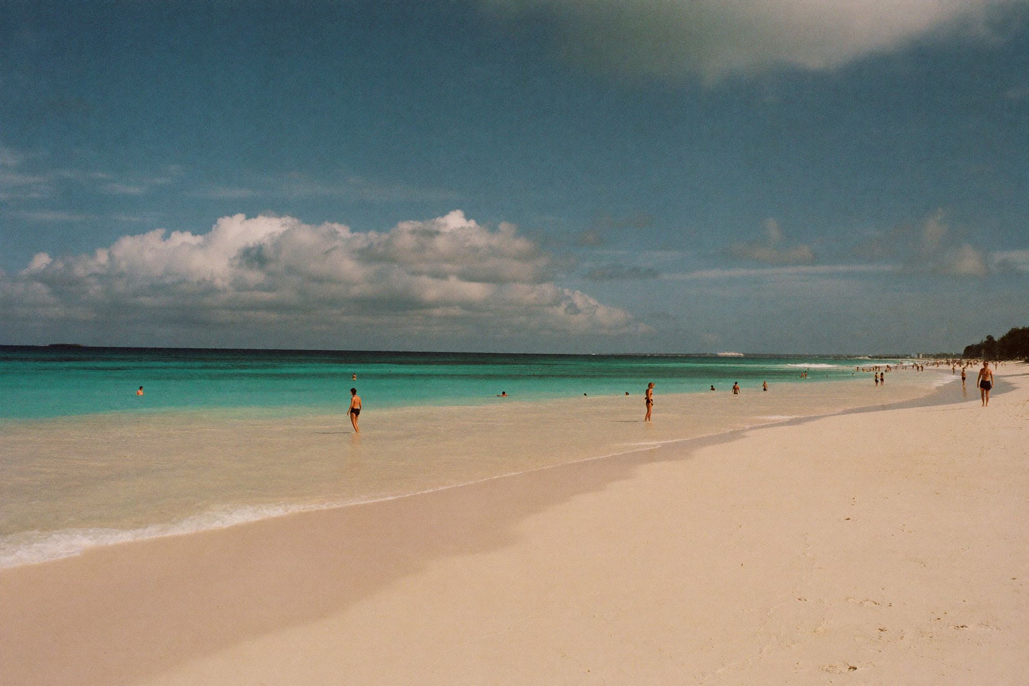 A wide empty white sand beach in Cancún with turquoise Caribbean water