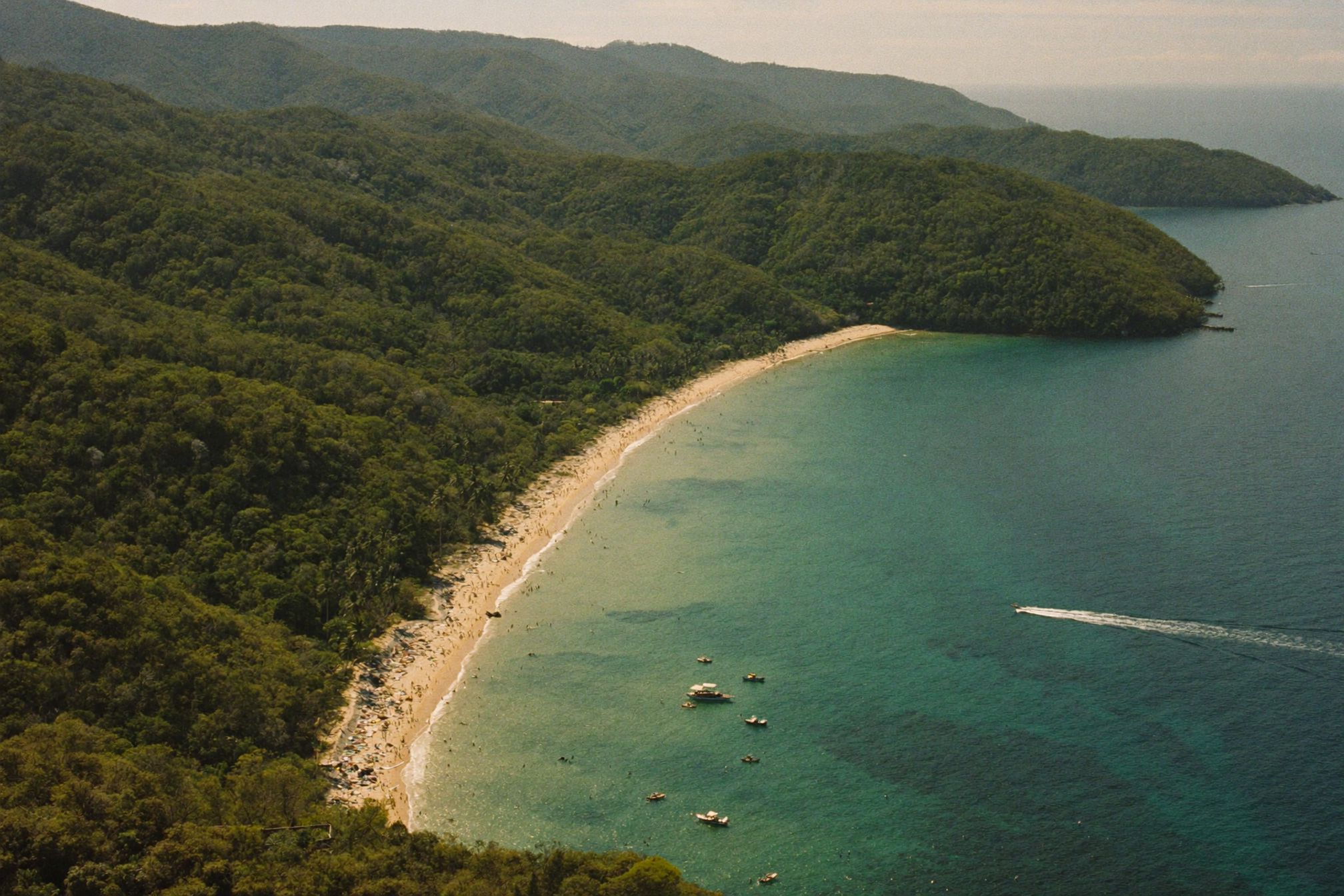 An aerial view of a Pacific bay with headlands and open water