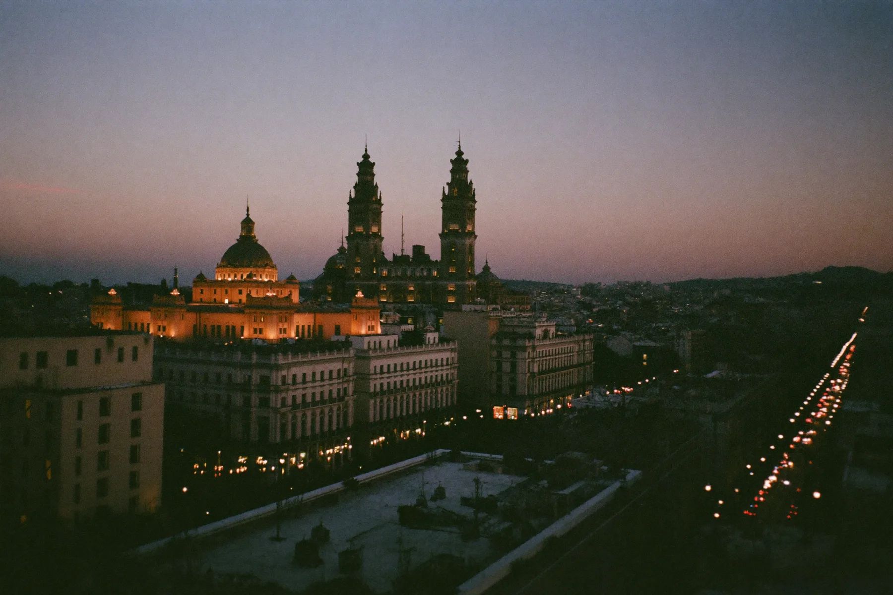 The historic centre of Mexico City lit at dusk with the cathedral and mountains behind