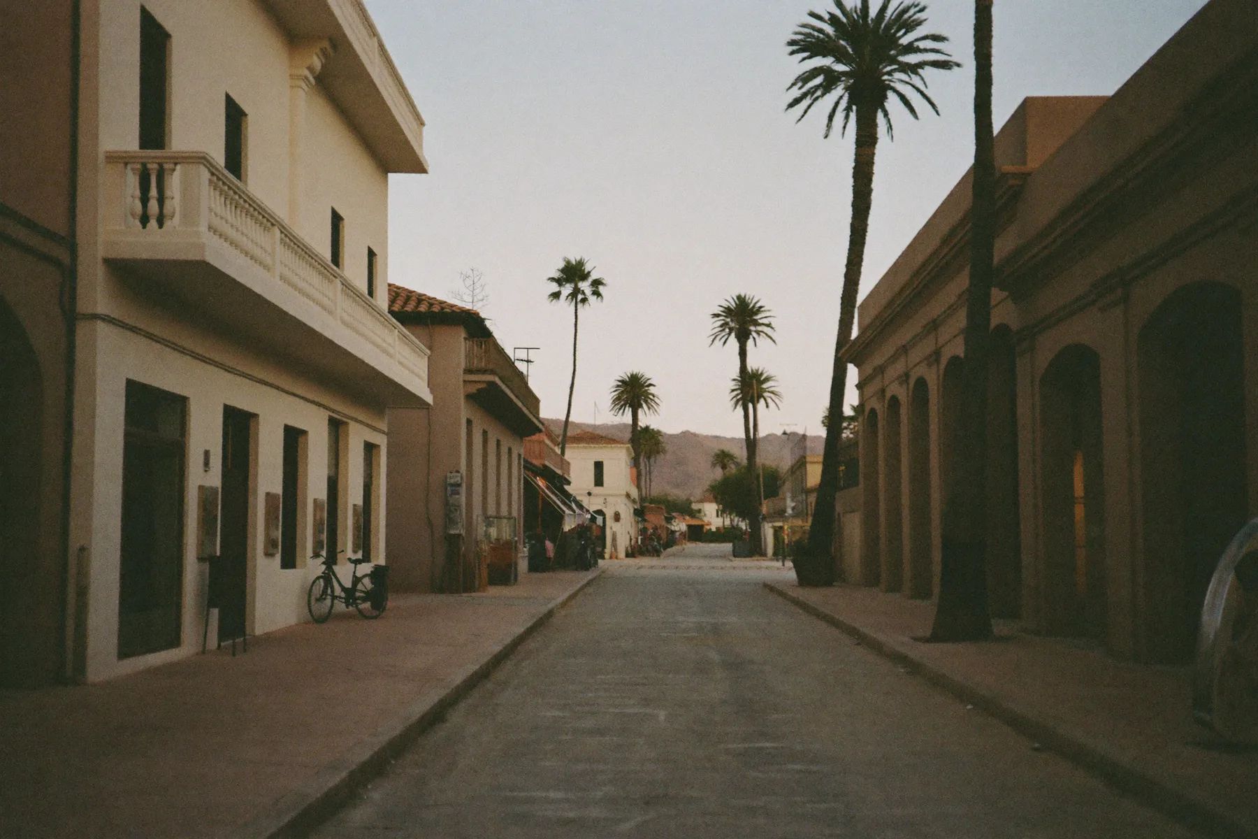 A colonial street in Todos Santos, Baja California Sur, with palms and low buildings