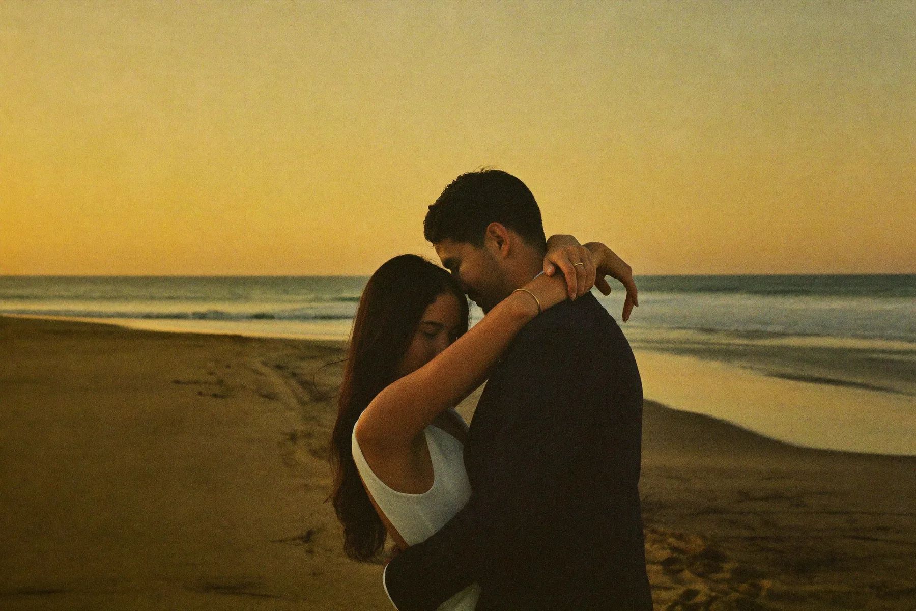 A couple on a Baja beach at sunset with the light going gold