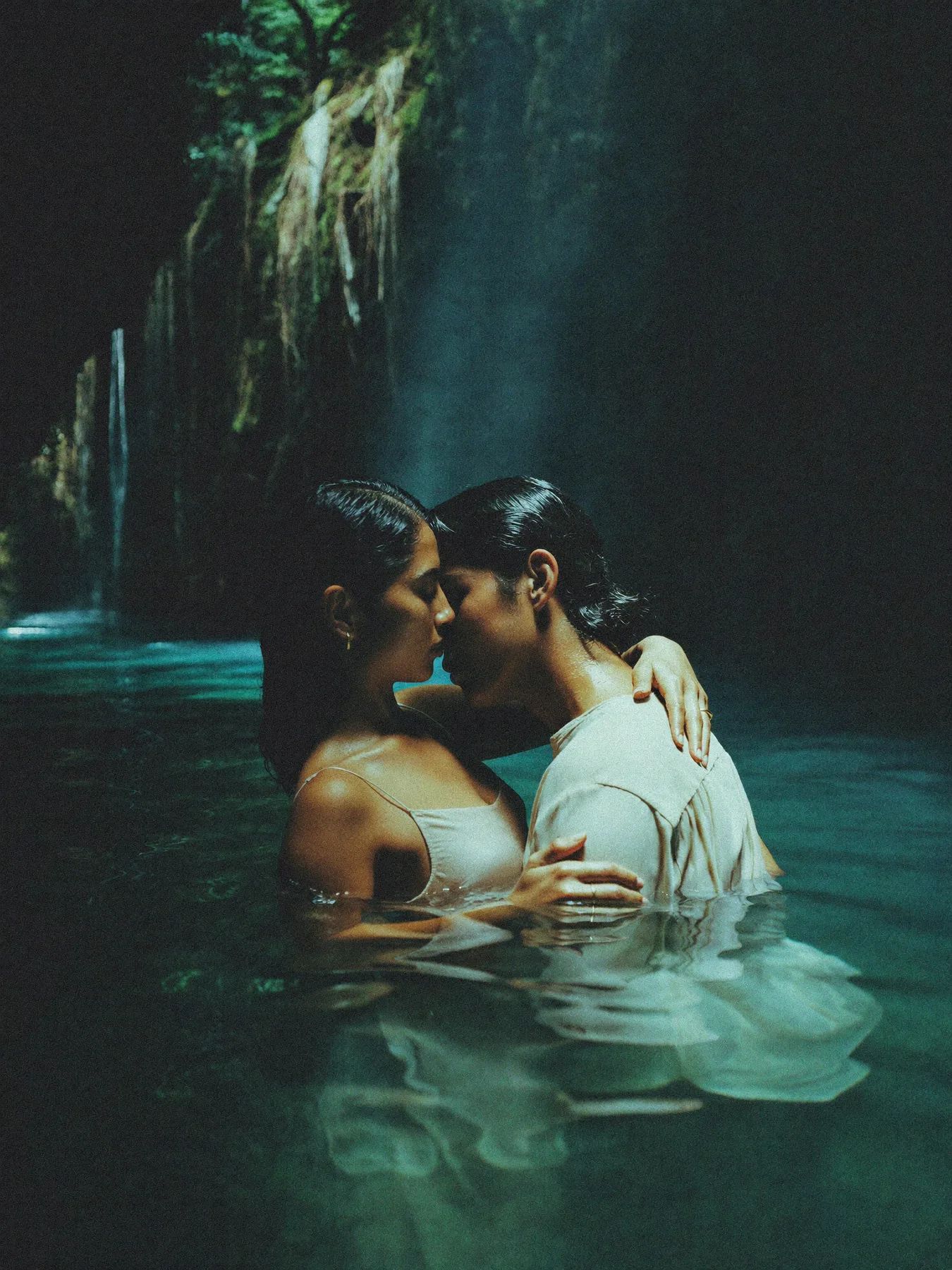 A couple in the light shaft of a cenote in the Yucatan