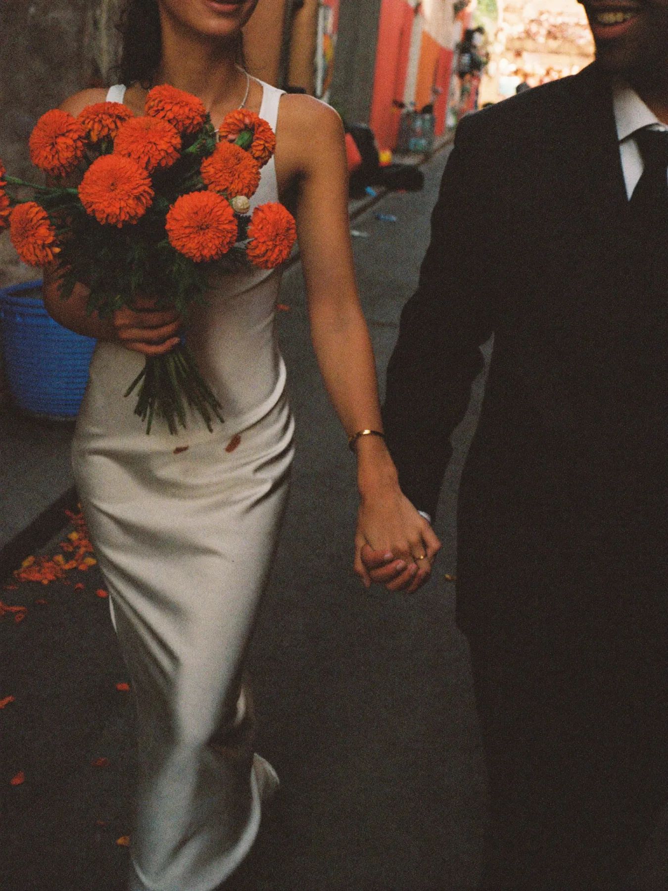 A couple walking with a bouquet of red flowers in Mexico