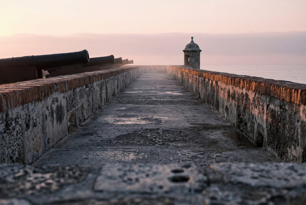Las Murallas empty at first light under a pink-gold sky over the Caribbean