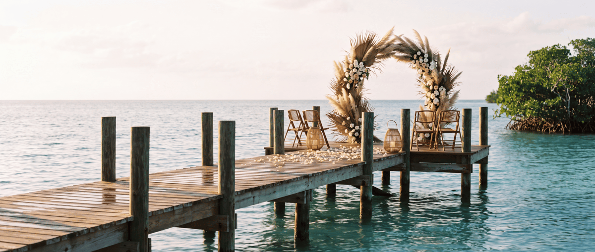 A private island dock dressed for a ceremony at golden hour